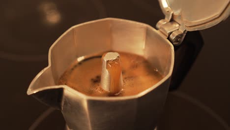 Brewing-espresso-coffee-in-moka-pot---bubbles-at-the-end,-closeup