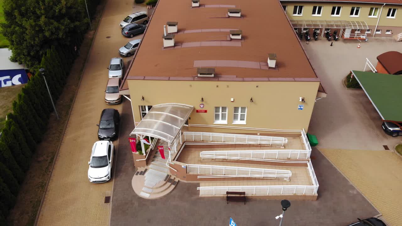 Entrance And Parking Area Of The Municipal Police Building In Gdansk, Poland. aerial drone tilt-down