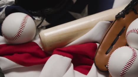 overhead baseball still life with bat ball and catchers mitt on american flag