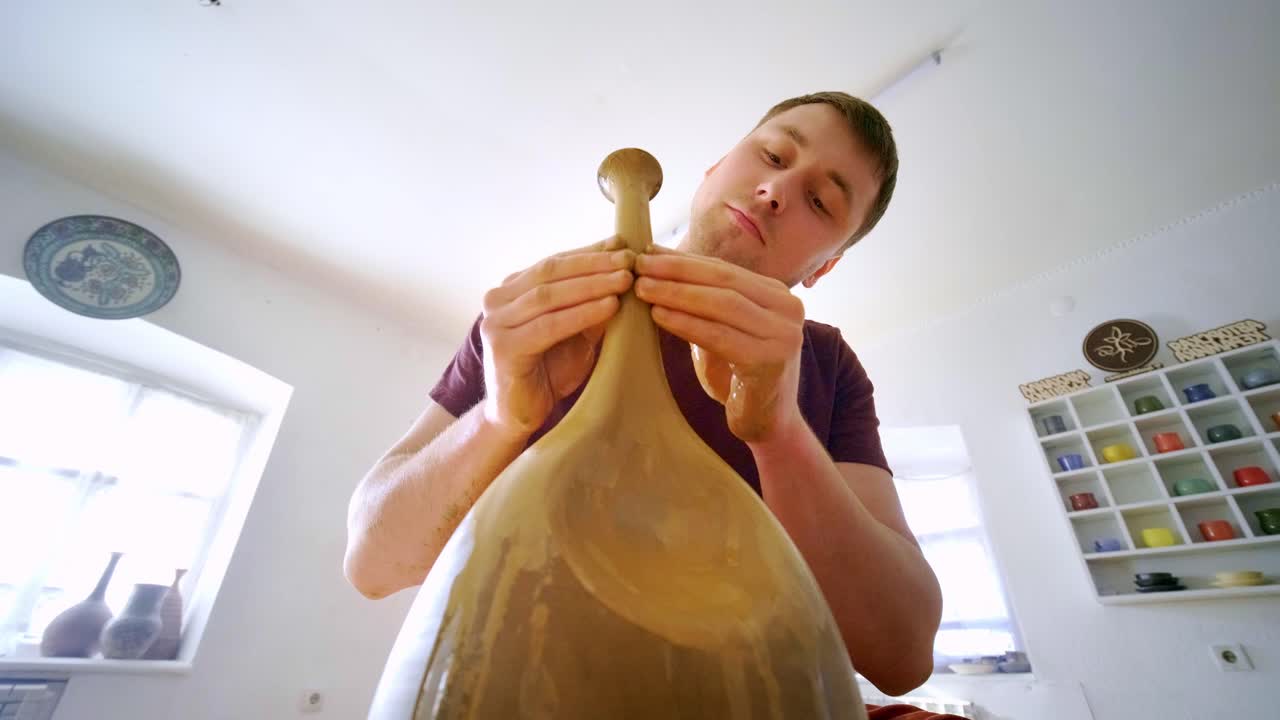 A skilled artisan passionately shapes a clay pot on the wheel, showcasing the intricate process of pottery-making in a serene workshop environment