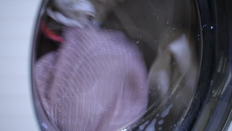 close up of clothes being washed in a laundry washing machine