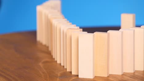 domino effect concept with wooden blocks falling on each other