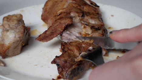 slicing into a tender rack of ribs, showcasing a close-up shot of juicy meat