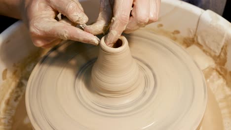 man's hands making clay ware on the potter's wheel