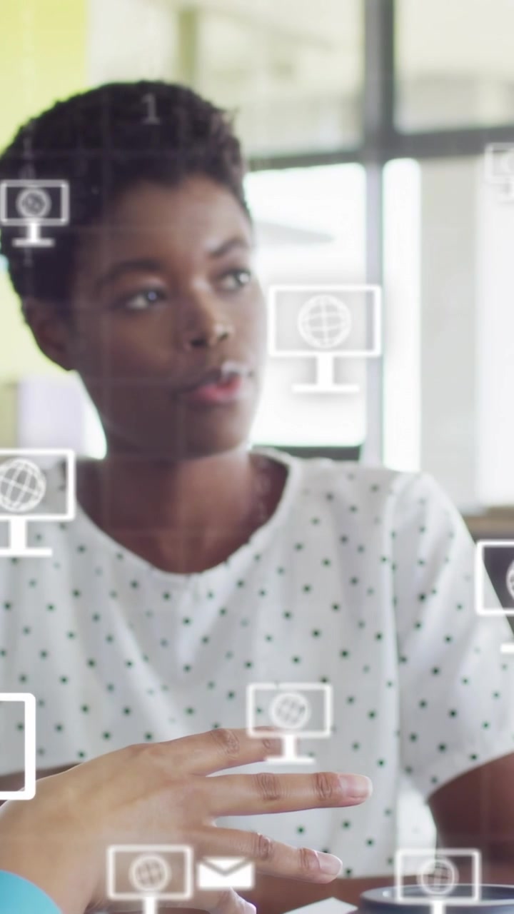 Vertical video: Man pointing at mockup, causing digital overlay while peer reaching cup in design