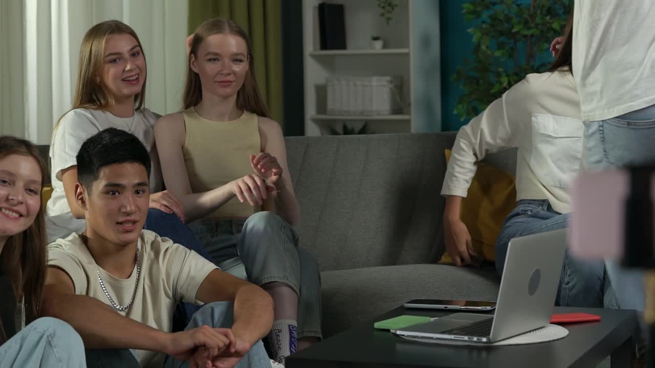 Teenagers having a video call in a living room