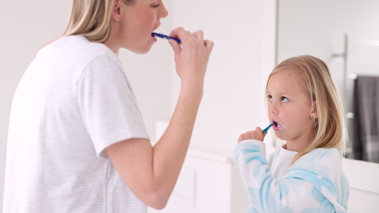 Mother and Daughter Brushing Teeth