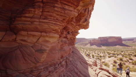 layered red rock formations in a desert canyon with a hiker