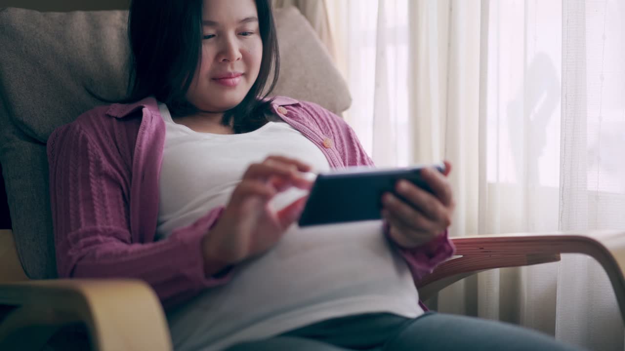 행복한 임신한 여성과 집에서 아기를 기대하고 있습니다.