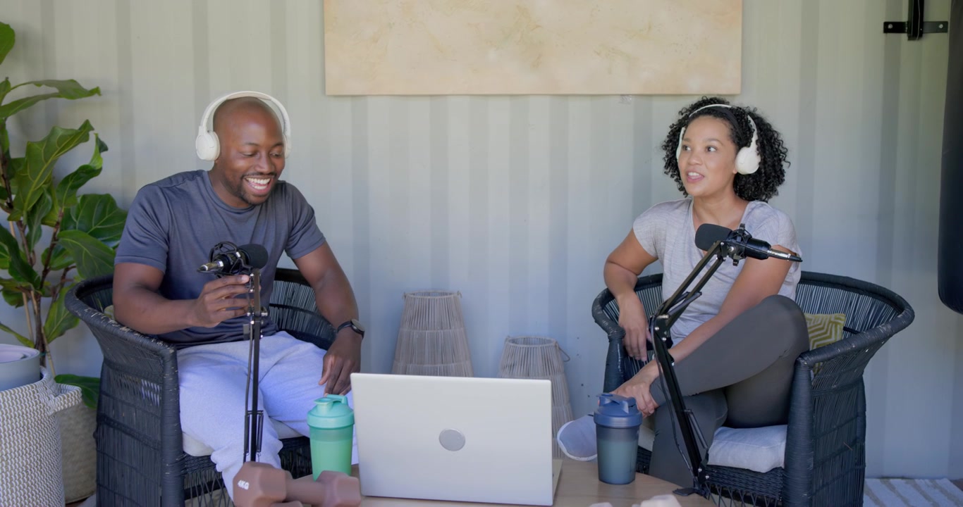 African American hosts starting podcast in studio after man picking up white headsets, tuning mics