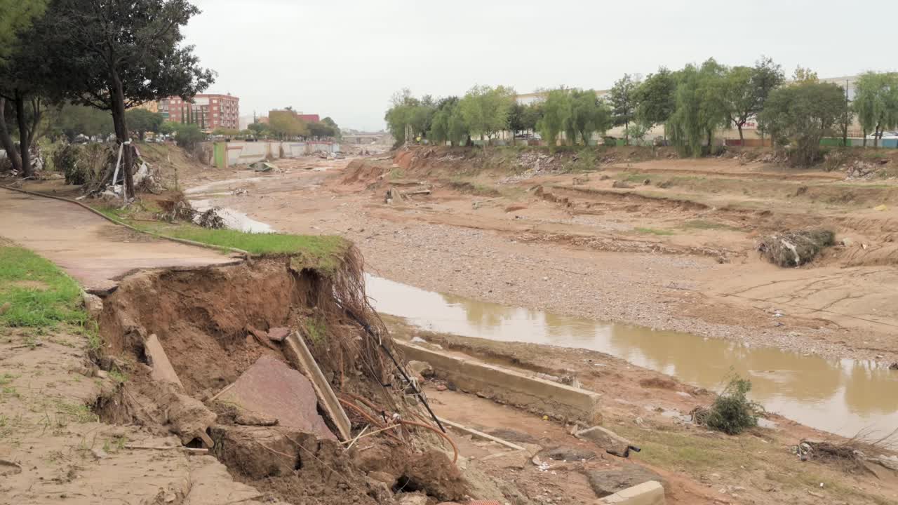 Danni devastanti da alluvione: erosione della riva del fiume e detriti