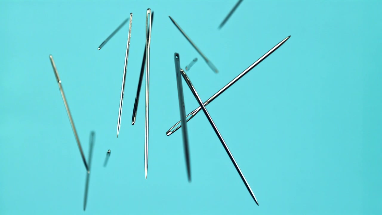 Multiple Sewing Needles Falling in Slow Motion Against Blue Background