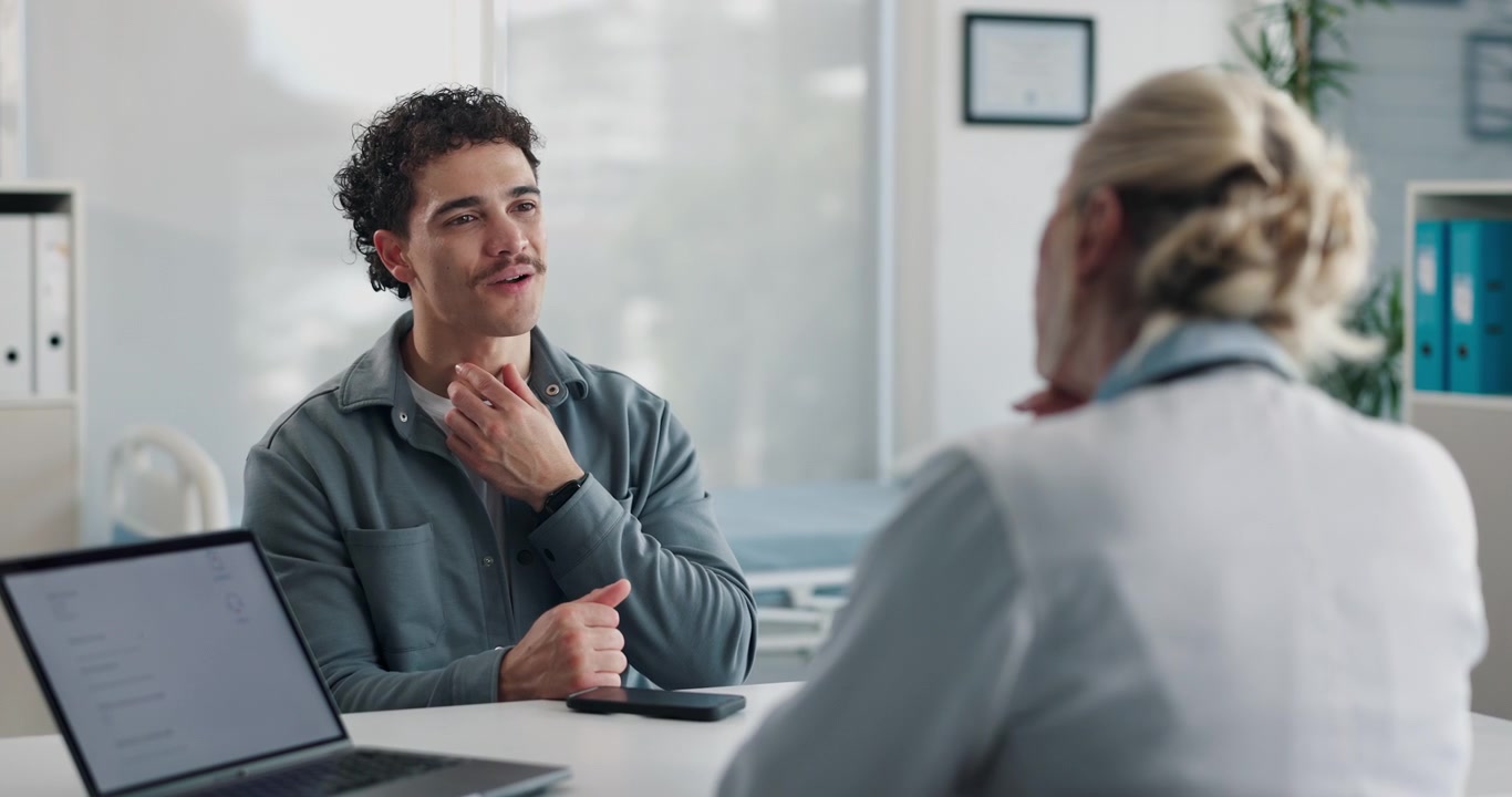 Young Man Discussing Symptoms with Doctor in Medical Office