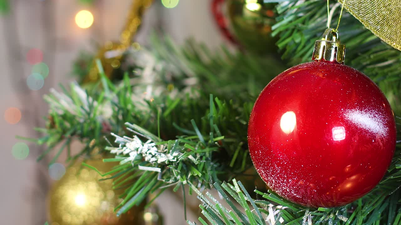 близко к красному рождественскому украшению на рождественской елке и мигающим огням