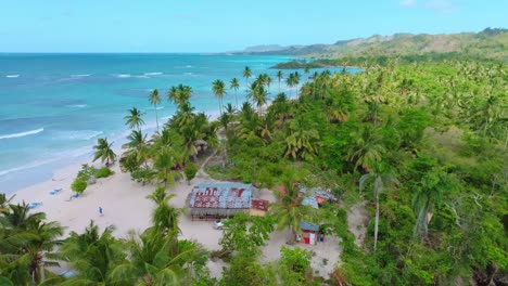 Flying-over-people-and-house-at-Playa-Rincon-beach-in-Dominican-Republic