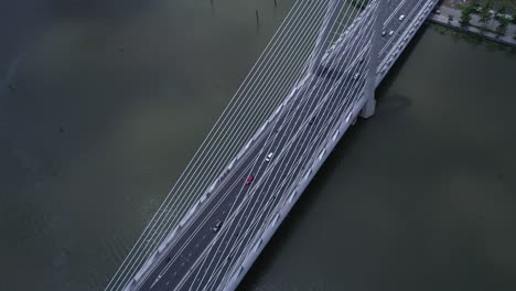 high aerial angle of suspension bridge over river with road traffic in dramatic light