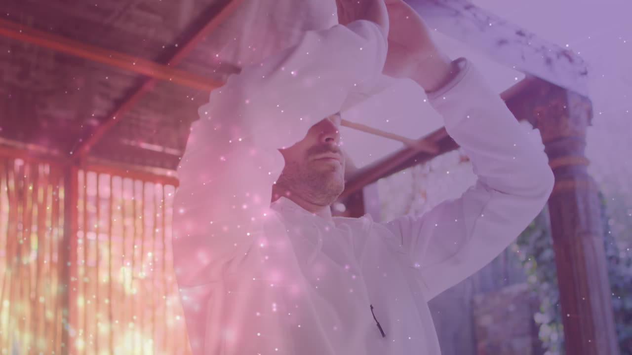 요가와 명상을 하는 백인 남성 위에 빛의 반점이 그려져 있습니다.