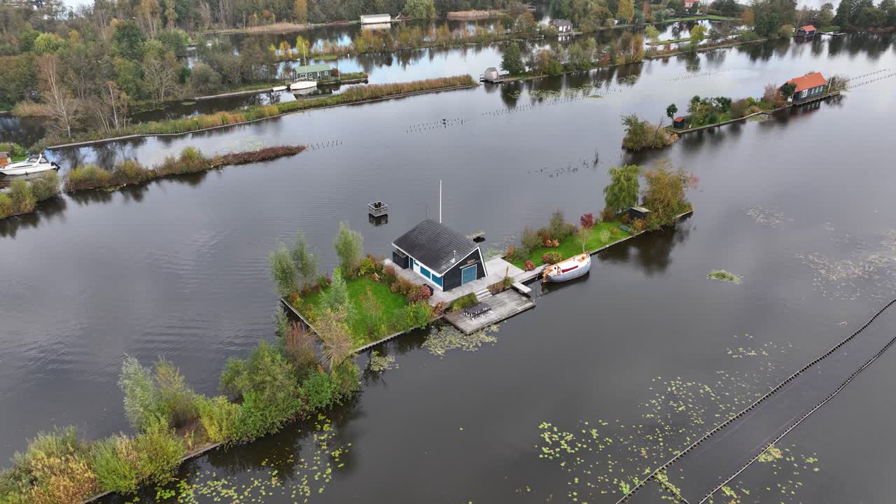 Small leisure house at miniature islands, Loosdrecht, large water sports and nature reserve. Aerial drone video.