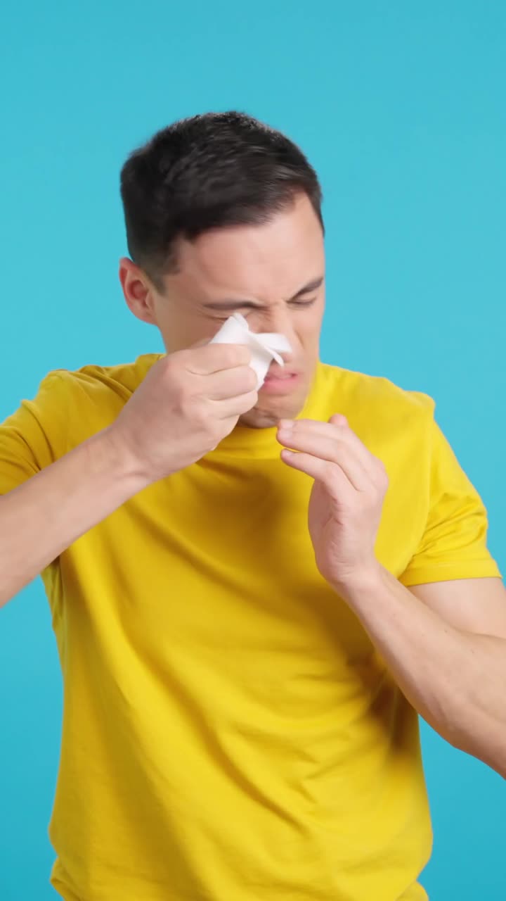 Man sneezing and blowing nose