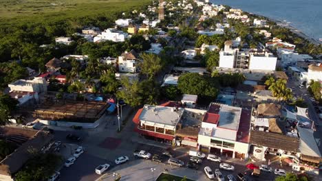 drone panning shot of a beach town in the mexican caribbean at sunset