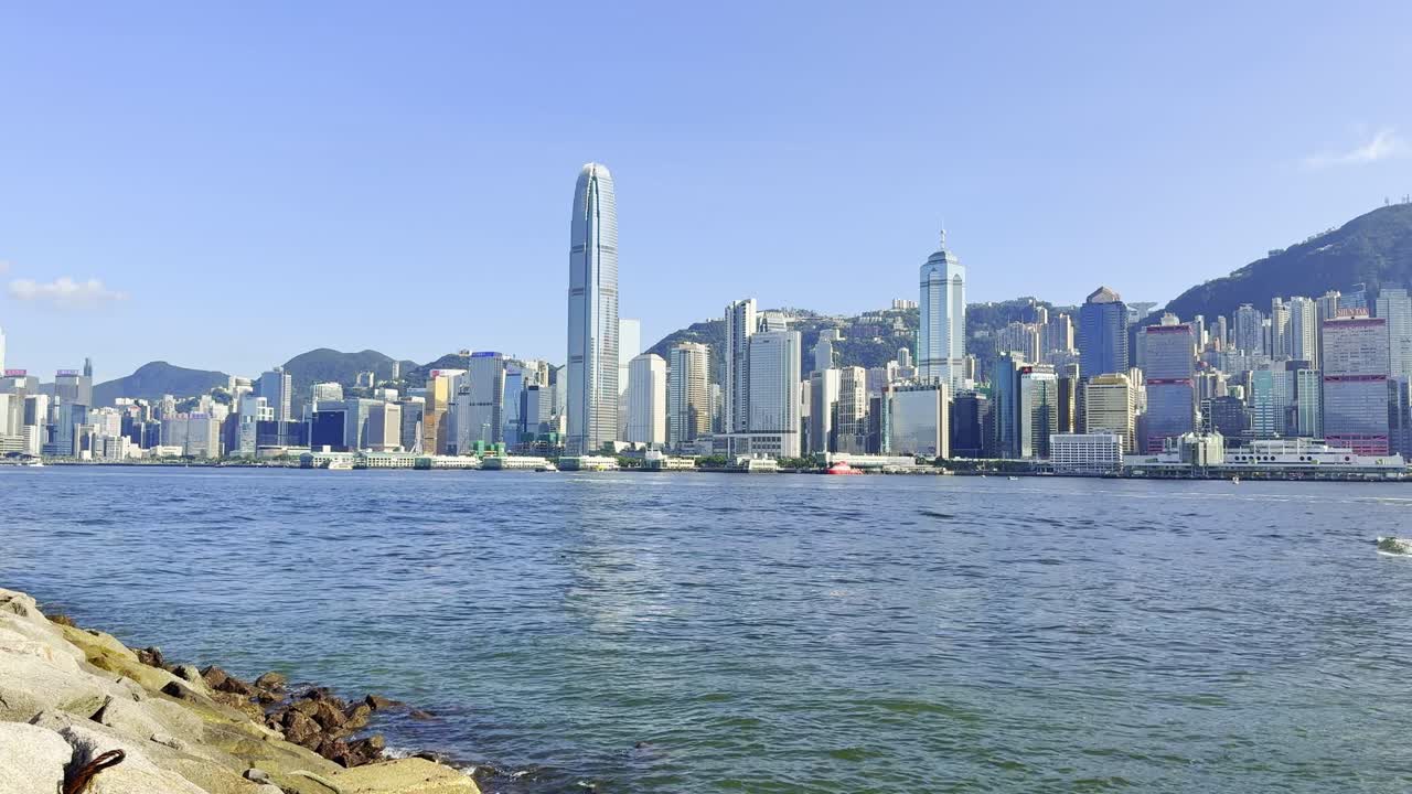 A scenic view of the sea in Hong Kong with calm waters reflecting the vibrant city skyline and surrounding landscapes