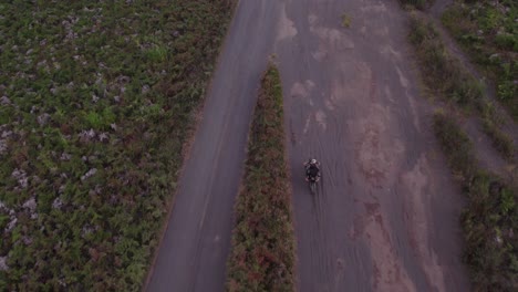 motocicleta conduce a toda velocidad en un camino de tierra en un mar de arena en bromo, antena