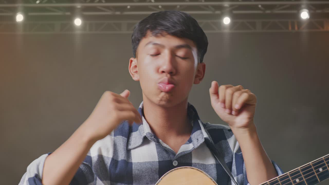 무대에서 기타 춤을 추는 아시아 십대의 클로즈업