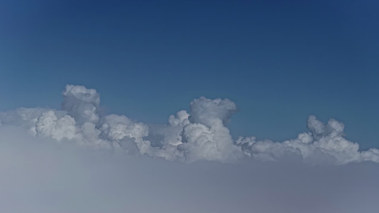 Flying above the beautiful fluffy white clouds in a blue sky day