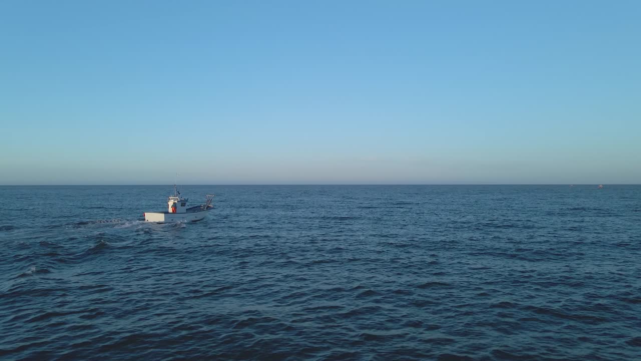 공중 촬영, 어선은 맑고 푸른 하늘-지중해를 배경으로 스페인 연안의 플라야 페논 델 쿠라 근처 넓은 바다에서 작은 파도를 가로질러 항해합니다.
