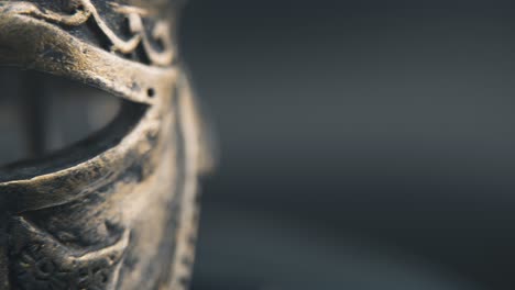 A-close-up-macro-detailed-shot-of-a-spartan-face-design,-warrior-ancient-greek-bronze-helmet,-on-a-360-rotating-stand,-studio-lighting,-4K-smooth-movement