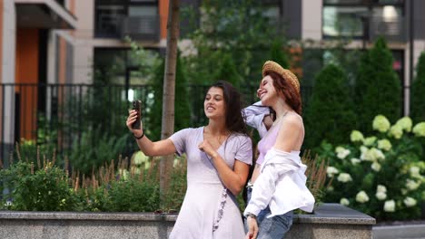 dos mujeres jóvenes tomando una selfie en un entorno urbano