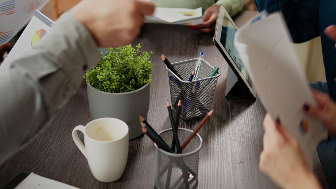 Diverse people analyzing charts data on documents and papers