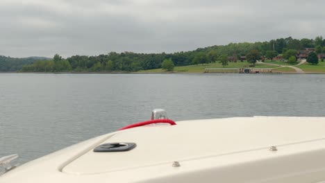 pov over the bow of the boat while moving along the shore of table rock lake in missouri