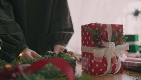 empaquetando y atando regalos de navidad en la mesa en el taller