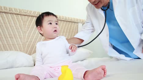 doctor examining baby on bed