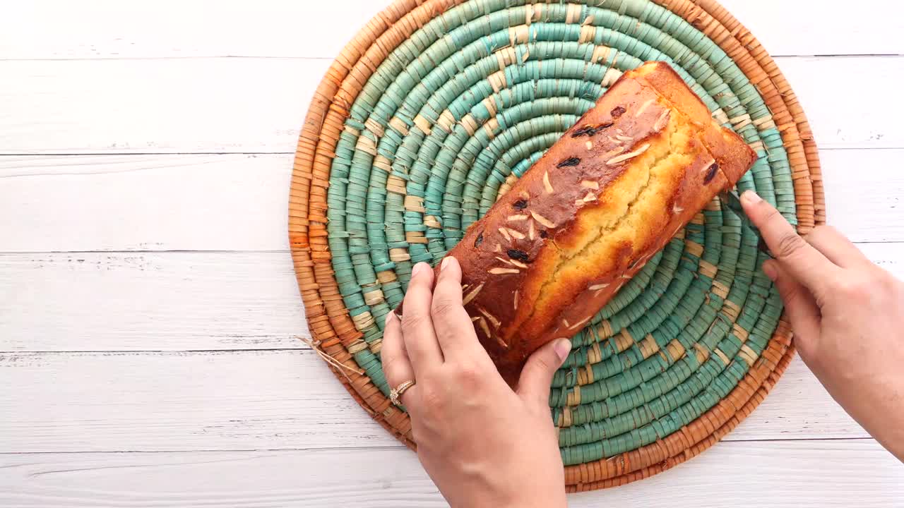 cortando un pastel de pan de pasas de almendra casero