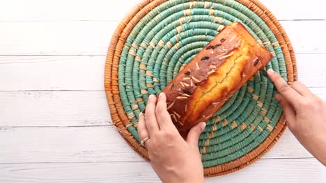 cutting a homemade almond raisin loaf cake