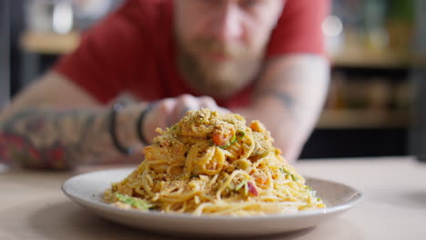 chef moving plate with spaghetti to camera