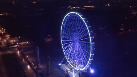 Rueda-De-Ferris-Vacía-En-La-Plaza-Por-La-Noche-Sin-Gente-Y-Luz-Azul-Desde-Una-Perspectiva-Aérea