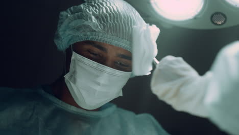 African-american-surgeon-performing-hard-operation-in-dark-clinic-ward-portrait.