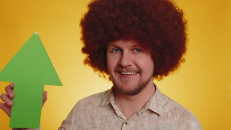 man with afro wig holding green up arrow and giving thumbs up