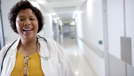 Portrait-of-happy-african-american-female-doctor-walking-in-hospital-corridor,-slow-motion