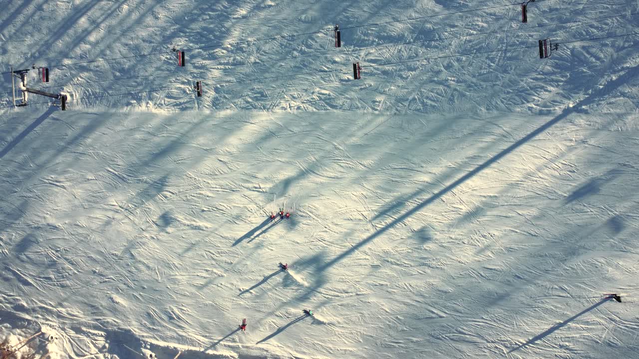 Chairlifts And People Skiing On Snowy Mountain During Winter In Saint-Sauveur, Quebec, Canada. aerial topdown shot