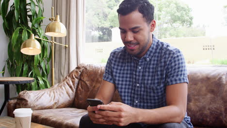 Junger-Hispanischer-Mann-Mit-Smartphone-In-Einem-Café