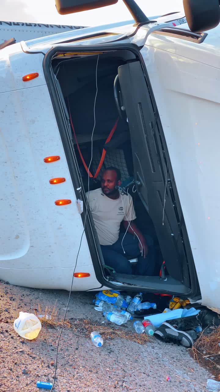 New York, USA, 25 settembre 2025: Autocarro semirimorchio bianco ribaltato a lato della strada. Un autocarro merci bianco giace su un fianco dopo un incidente stradale su un ciglio stradale sterrato.