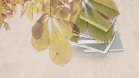 animation of leaves over books on wooden background