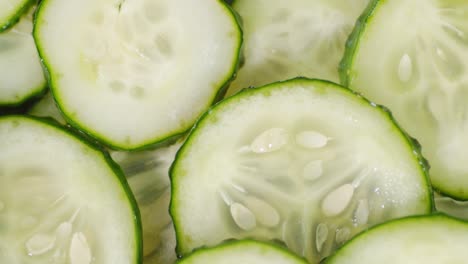 round slices of fresh cucumber slowly rotate.