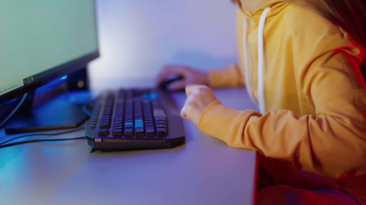 Young woman keyboarding on computer. Happy young woman sitting at room and using computer