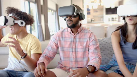 at home, using vr headsets, diverse friends enjoying virtual reality gaming on couch