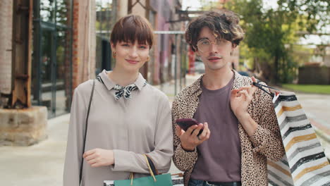 Portrait-of-Young-Friends-with-Shopping-Bags-on-Street